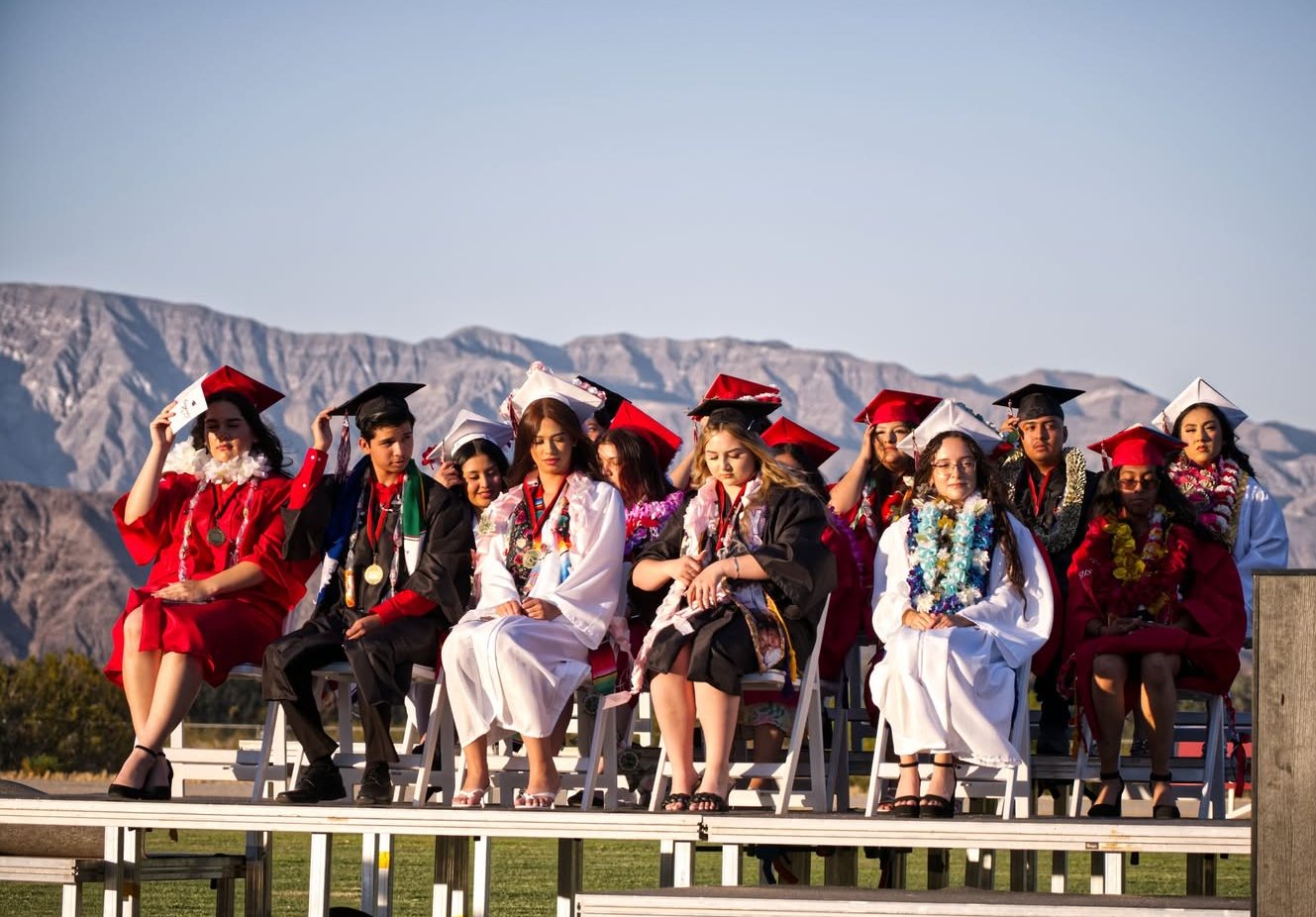 Borrego Springs High School graduates seated in caps and gowns, the desert mountains behind them