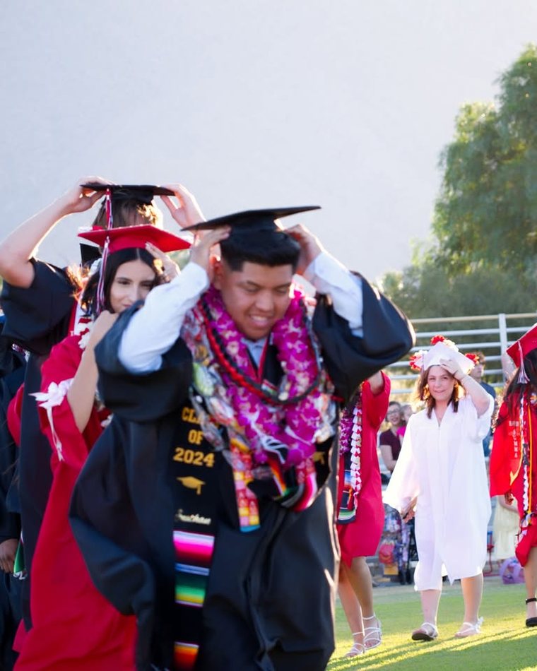 Graduates in caps and gowns walking together on commencement day
