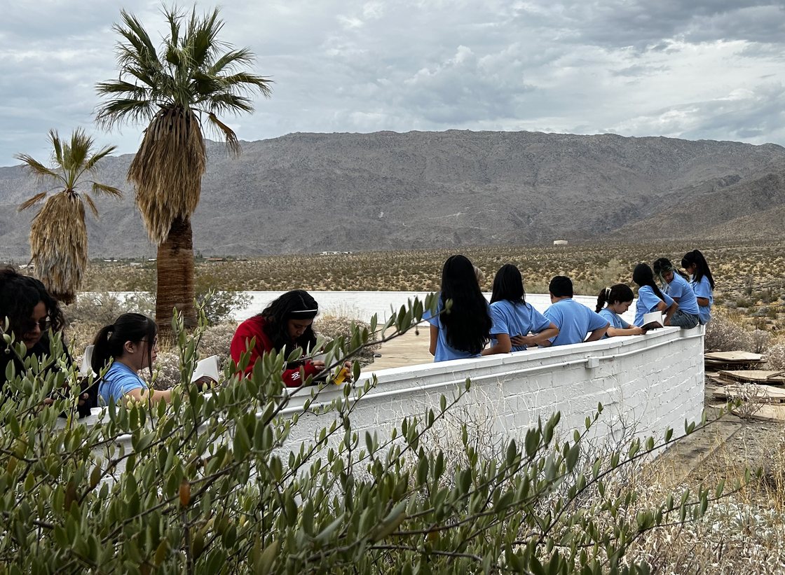 Learning Academy students reading outdoors at a desert overlook above Borrego Springs