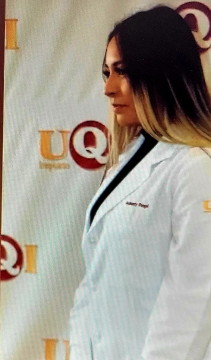 A second BASIC scholar in a white coat at the same medical school ceremony