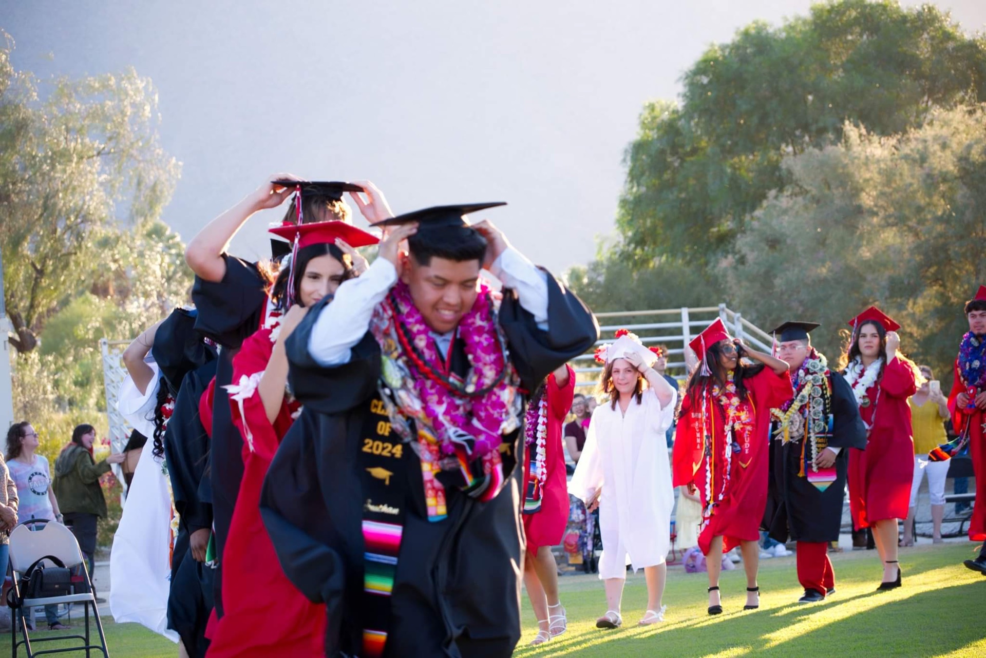Borrego Springs High School graduates in caps and gowns turning their tassels at the outdoor commencement ceremony