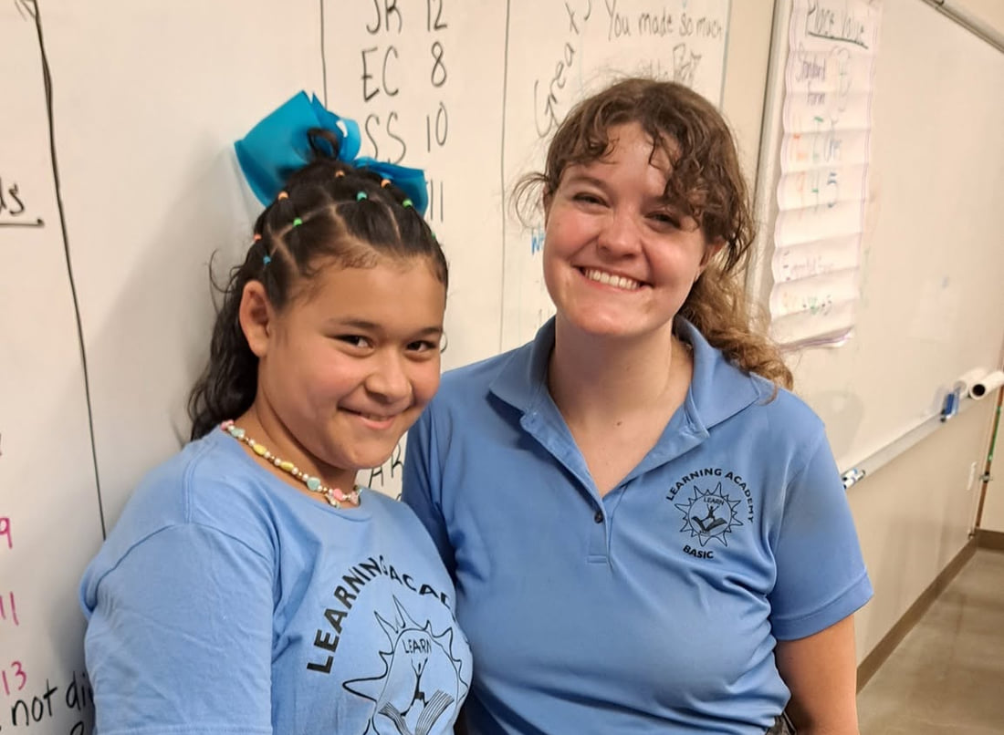 A BASIC Learning Academy student and an instructor standing together at a classroom whiteboard