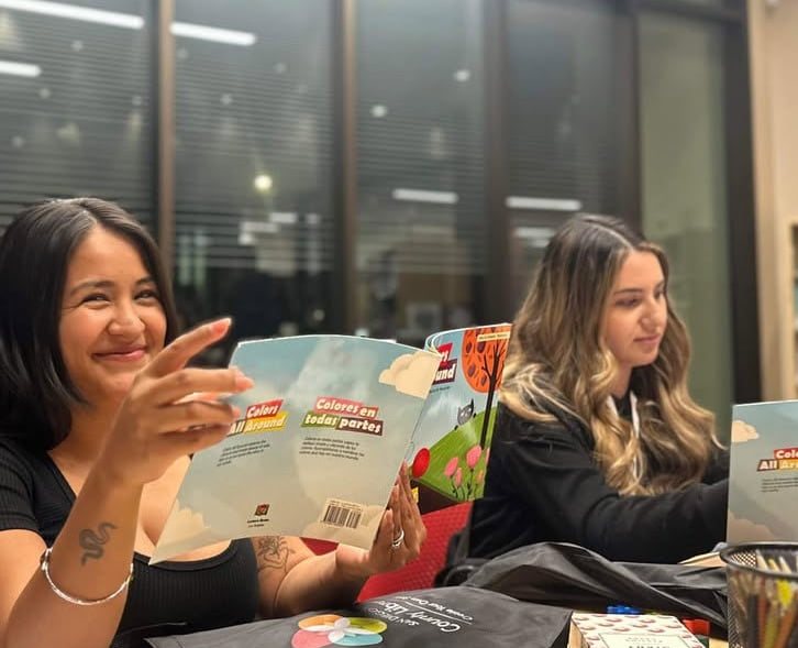 Two volunteers preparing bilingual English and Spanish picture books for BASIC’s early literacy program